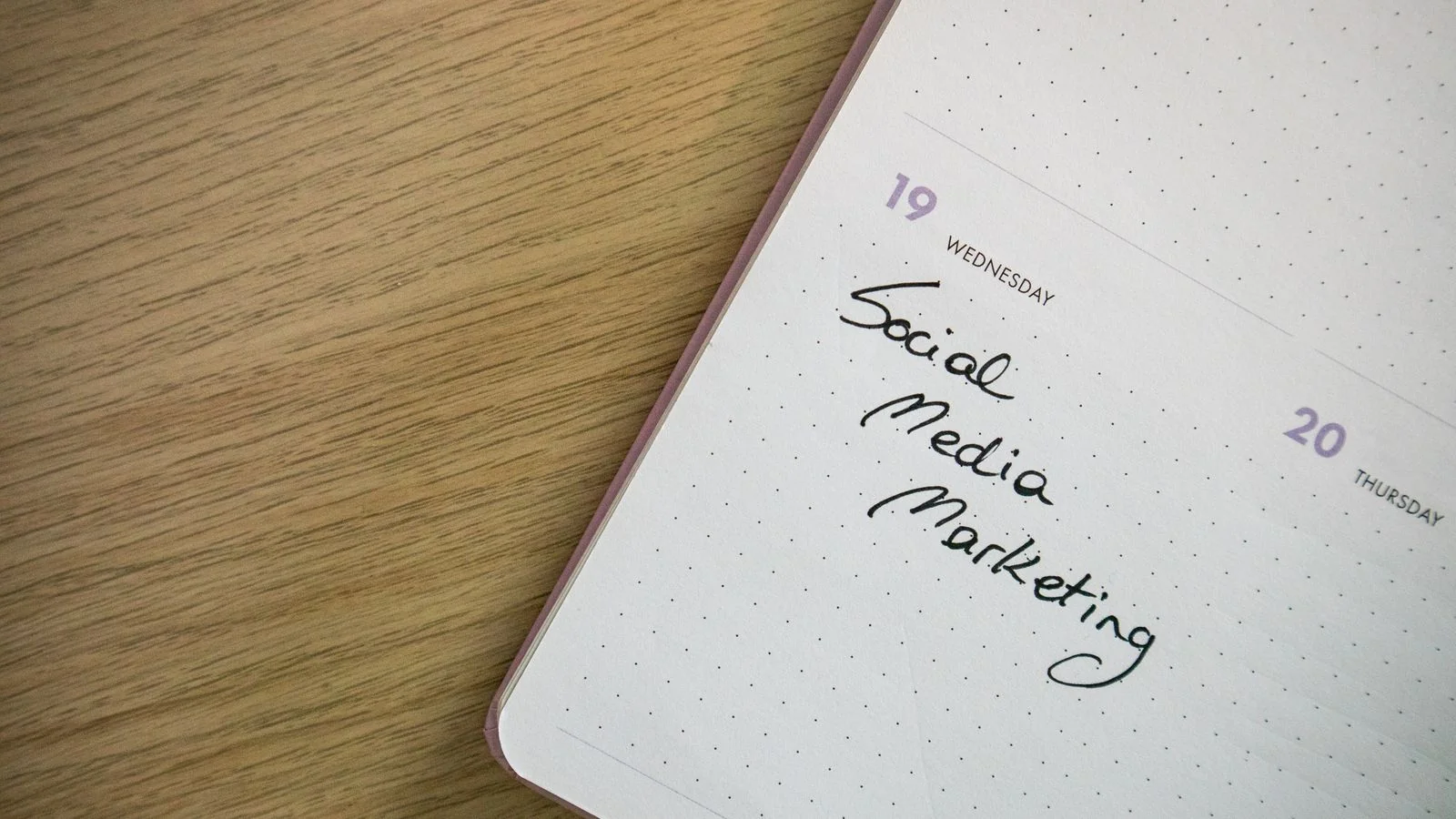 A close-up of a notebook page with social media marketing notes handwritten on it