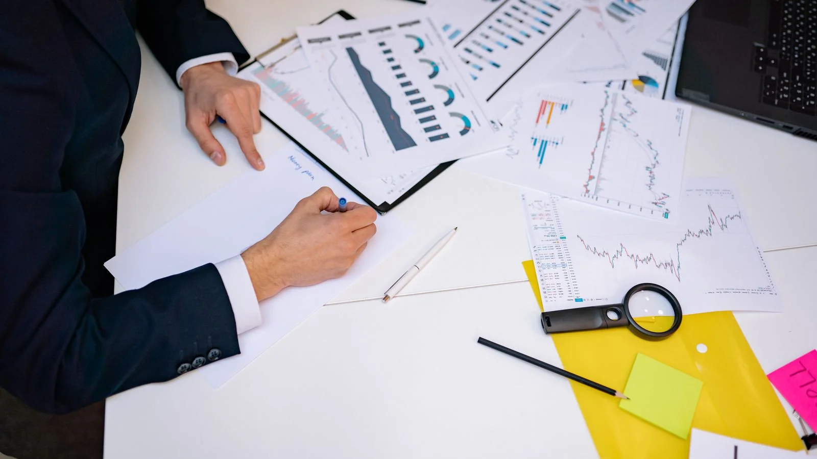 Desk covered in financial charts and reports used to compare marketing channel returns