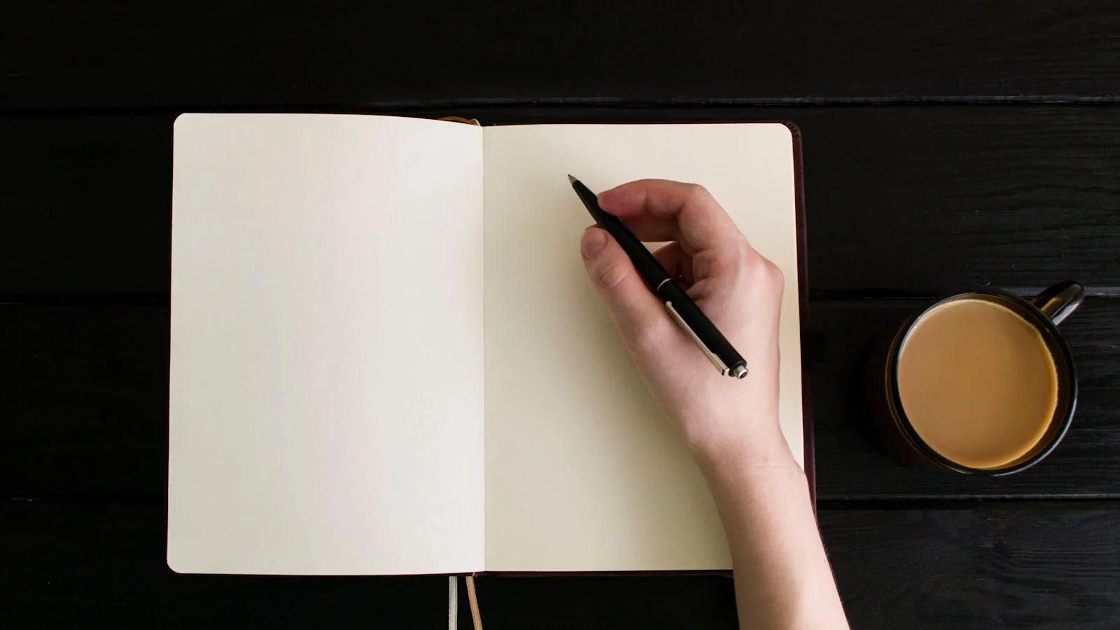 Founder writing the first draft of a thought-leadership post in a small notebook over coffee