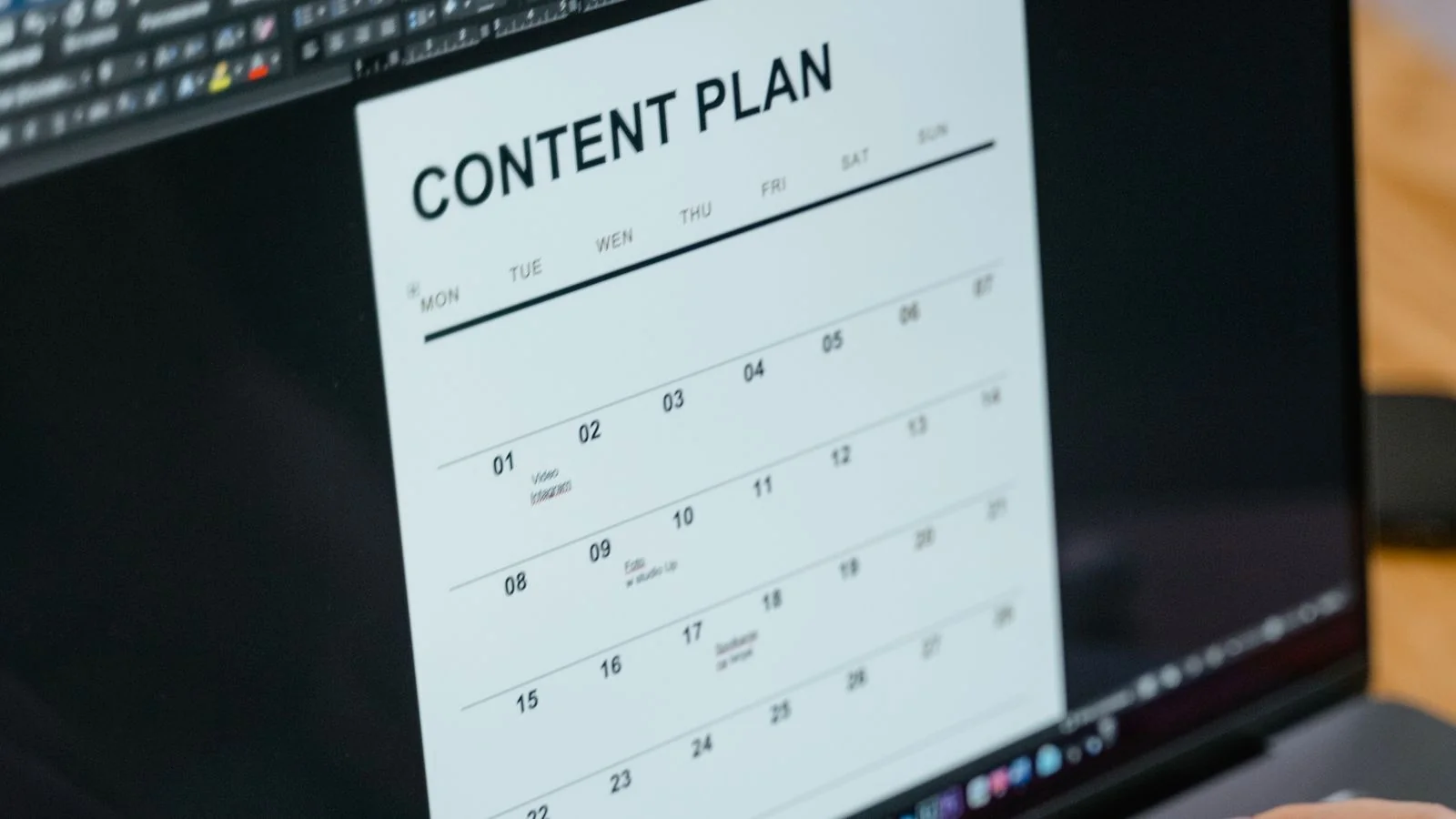 Hands typing on a laptop showing a content plan document, the asset an AI engine can actually cite
