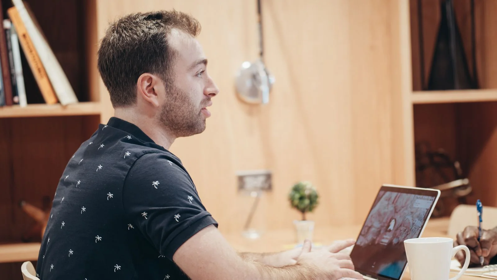 A man working on a laptop in a cozy office, producing content that returns to a theme