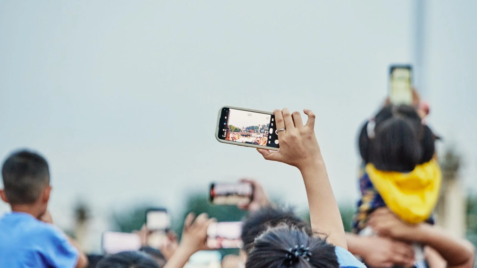 Crowd at an event holding up smartphones to film, a picture of the creator audience