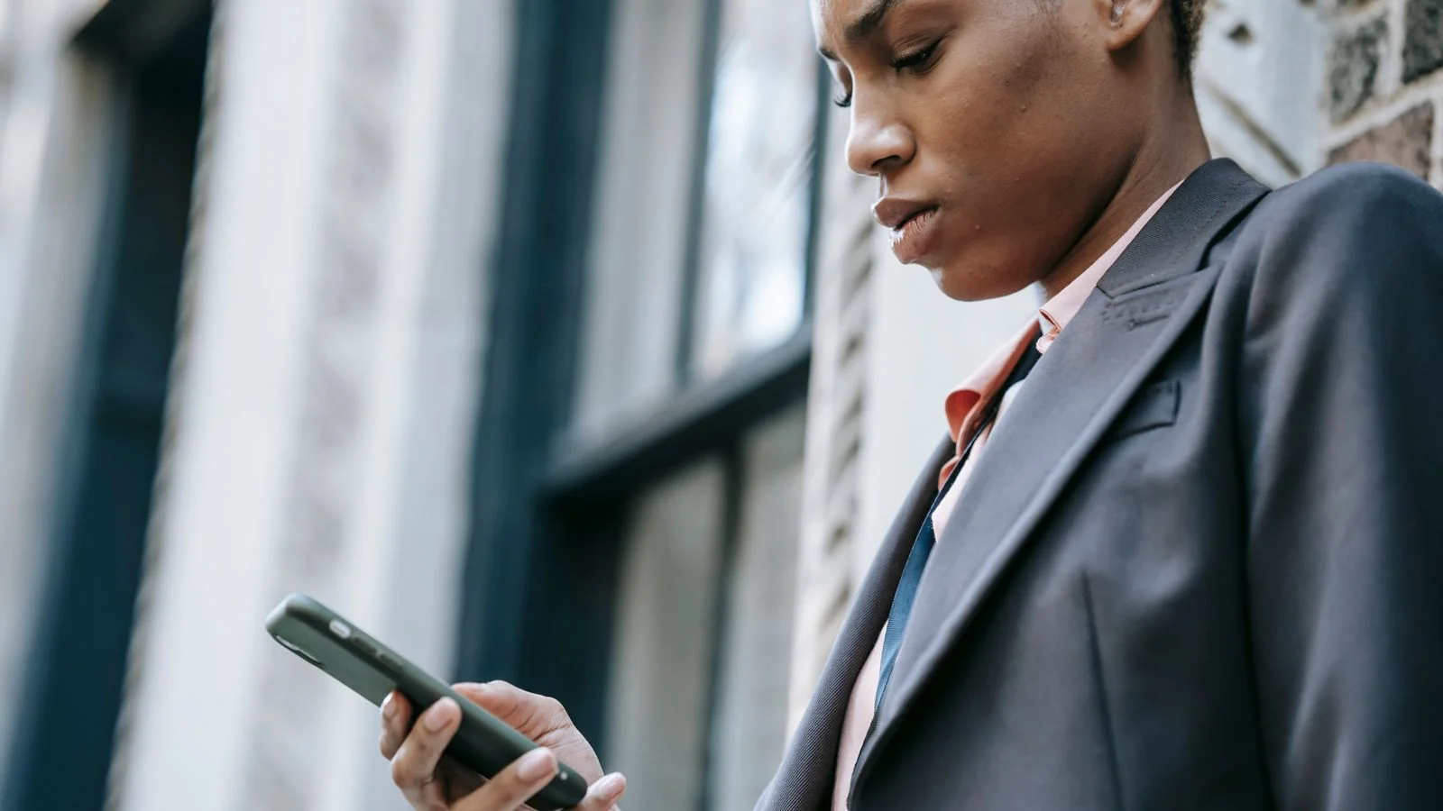 Woman in a tailored jacket texting on her smartphone, the kind of exposure removal services target