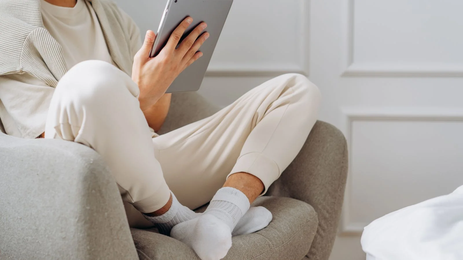 A person reading news on a tablet at home, where coverage either reaches a decision-maker or does not