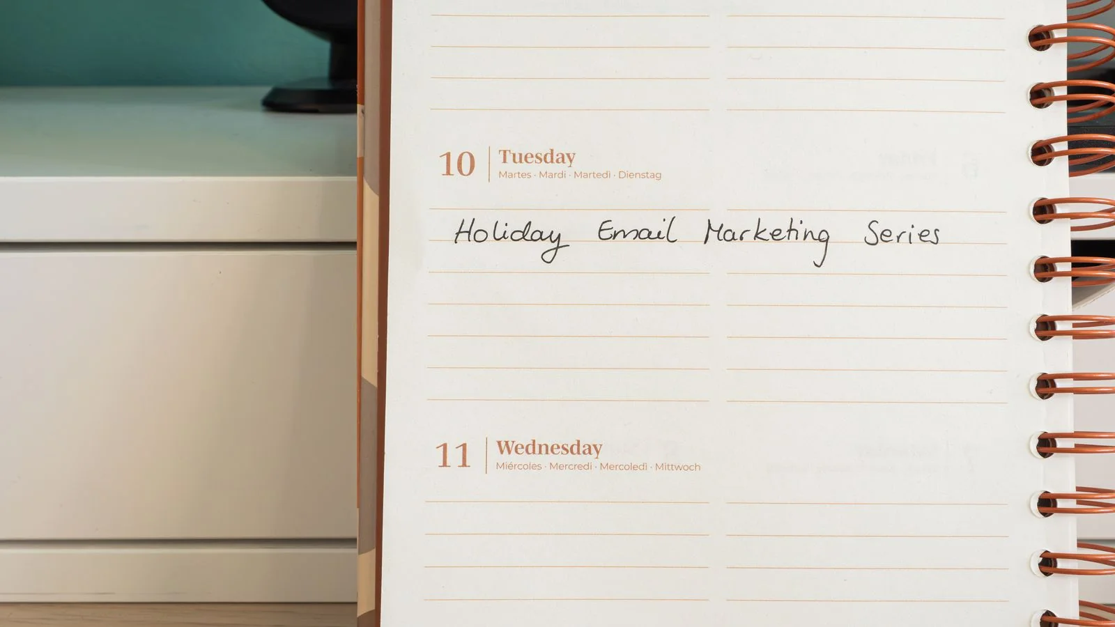 A planner open on a desk with a handwritten content note, the near-term detail a calendar needs