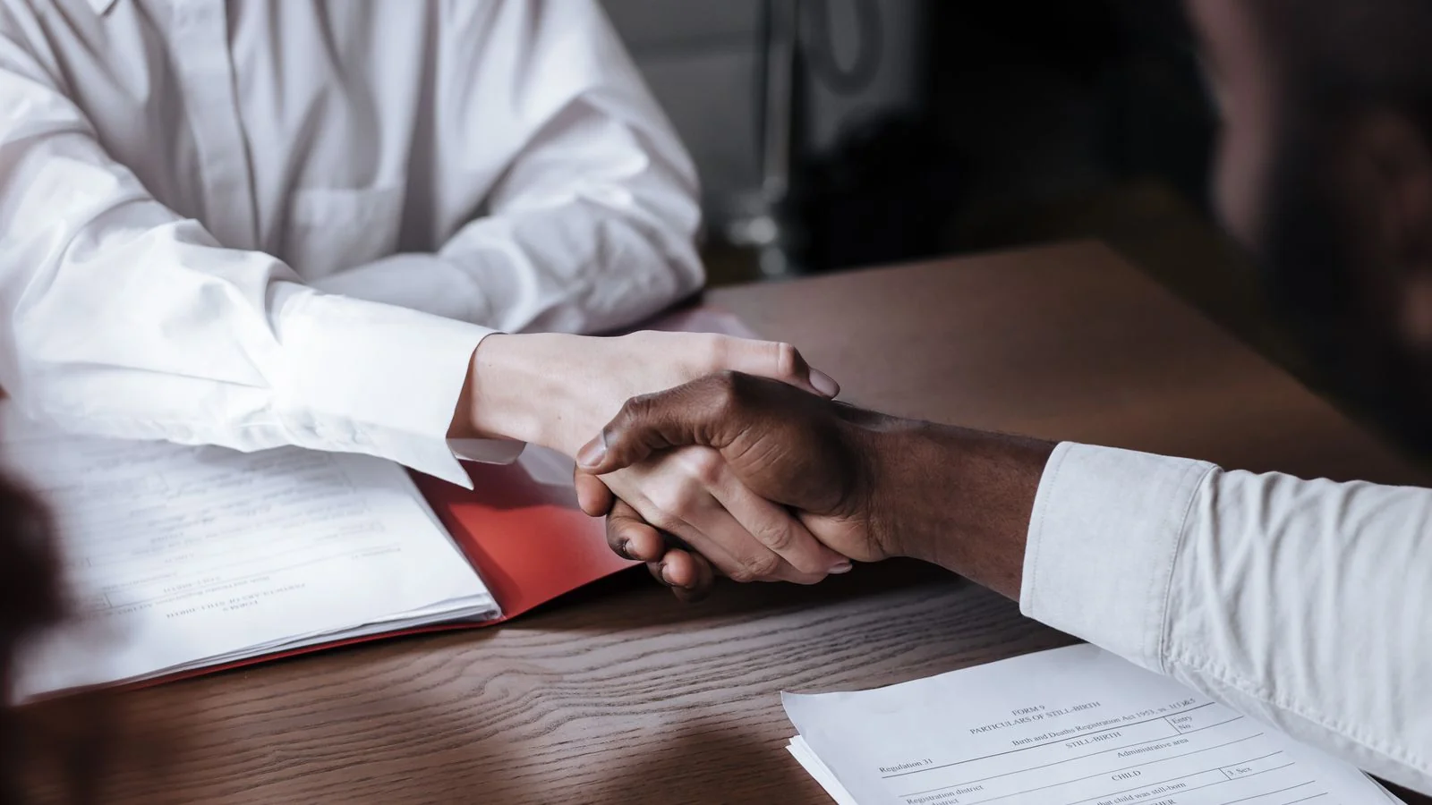 A close handshake over a contract, standing in for the deal you are about to sign with a wire
