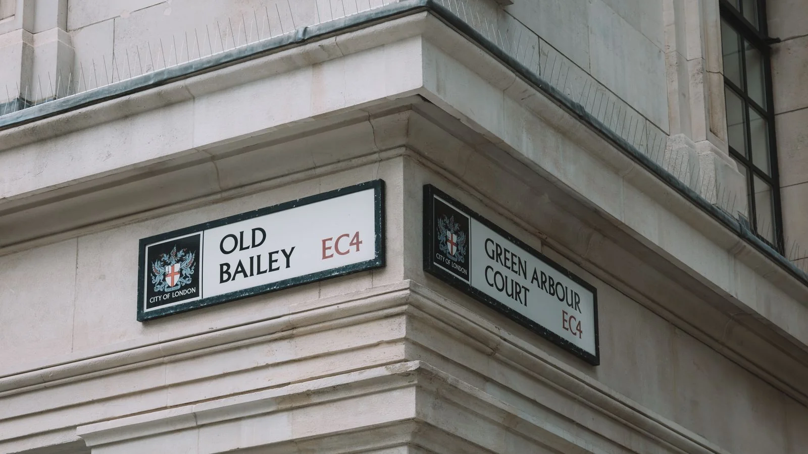 London street signs for Old Bailey and Green Arbour Court on a brick corner, like an address machines can find