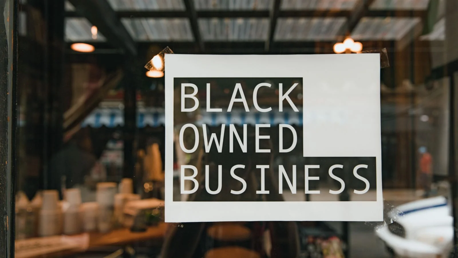 Small business sign taped inside a shop window, the kind of storefront that survival data tracks