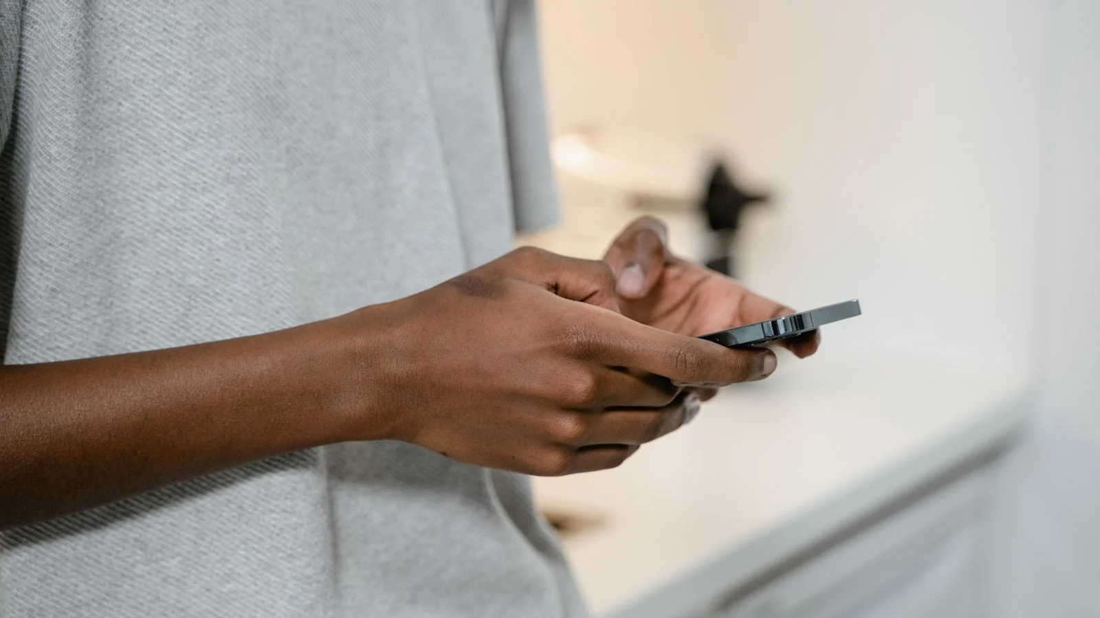 A person typing on a smartphone, the act a review farm industrialises