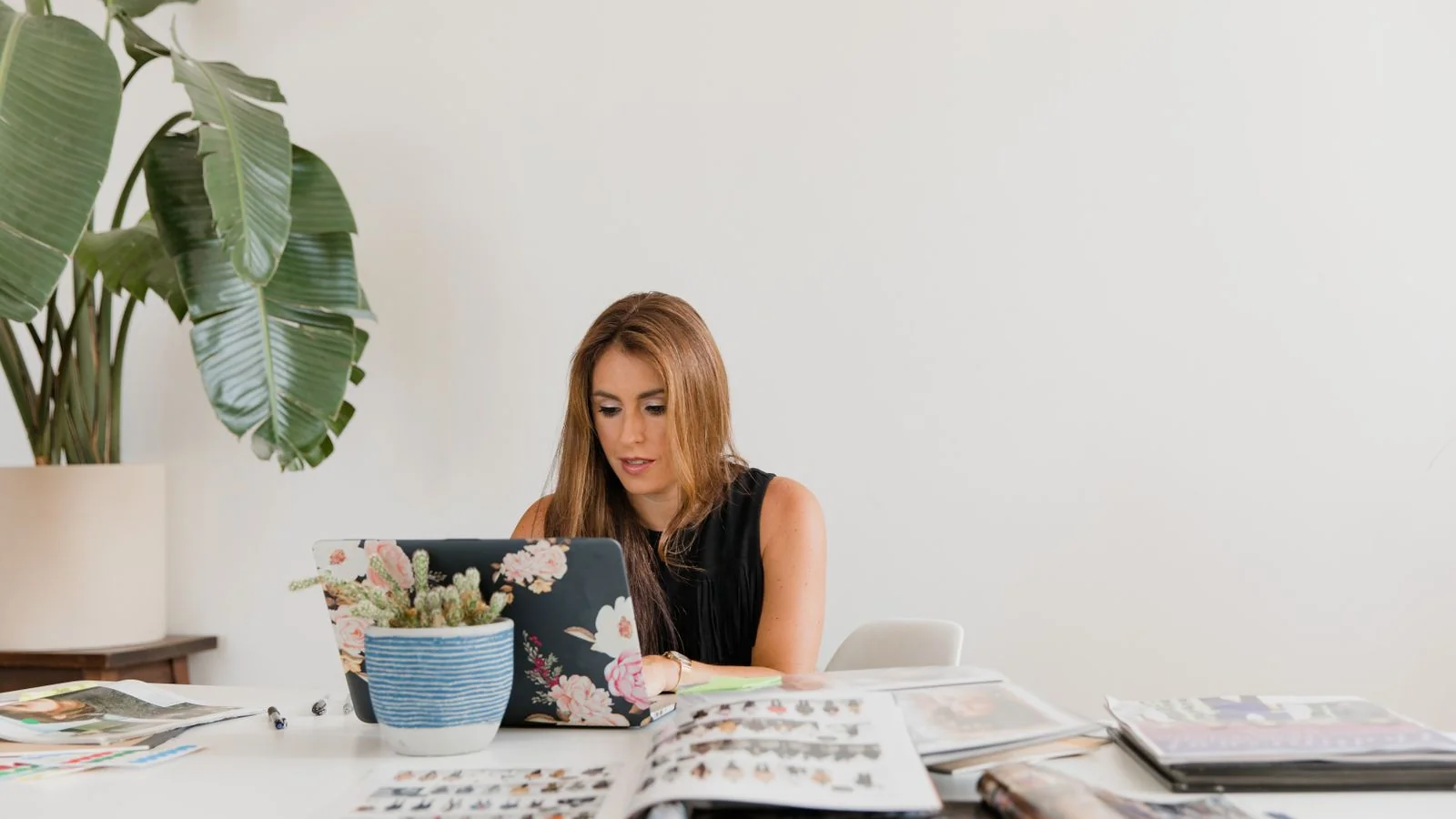 A professional working at a desk with magazines and a laptop, building a personal authority profile