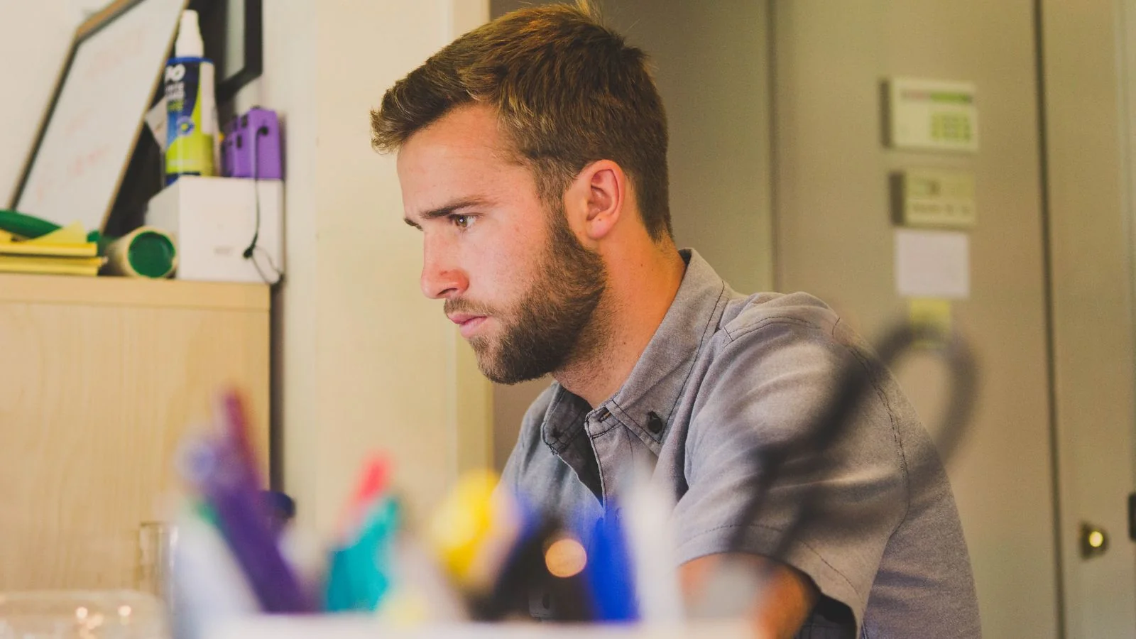 A focused founder working alone at a desk, the early and unglamorous work of building a reputation in public