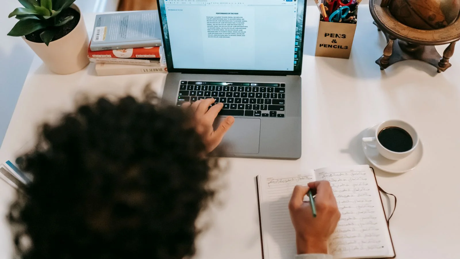 An author typing on a laptop near a cup of coffee at home, the slow work of writing in your own voice