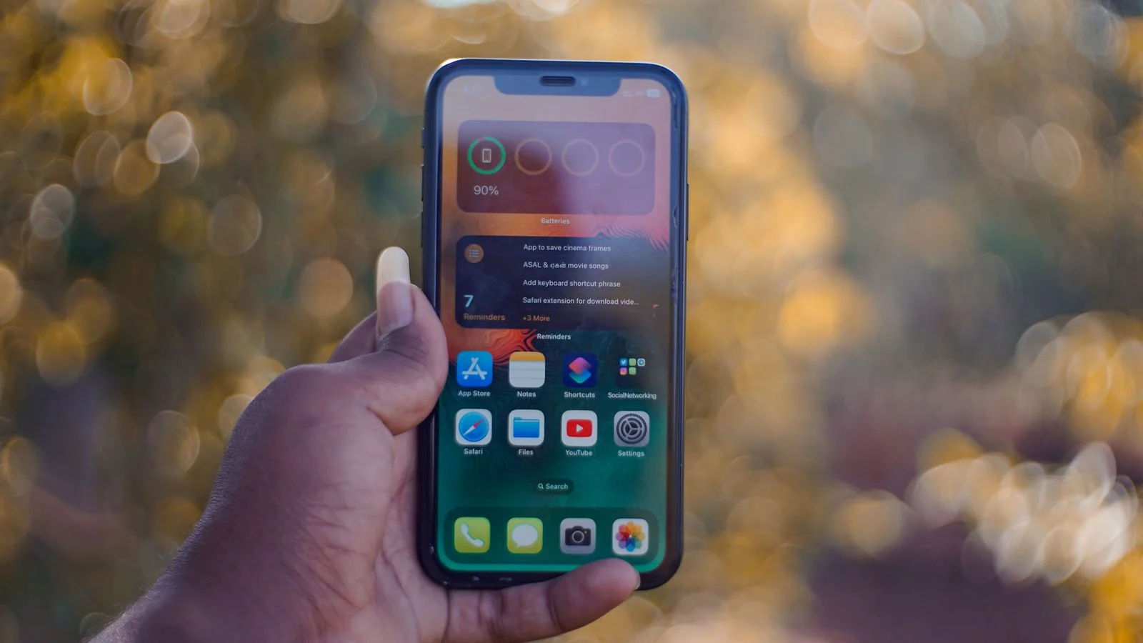 A hand holding a phone outdoors, where most of the uncounted AI search activity happens