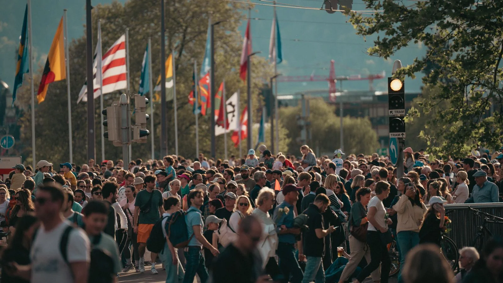 Crowded city street with a diverse group of people walking in sunshine