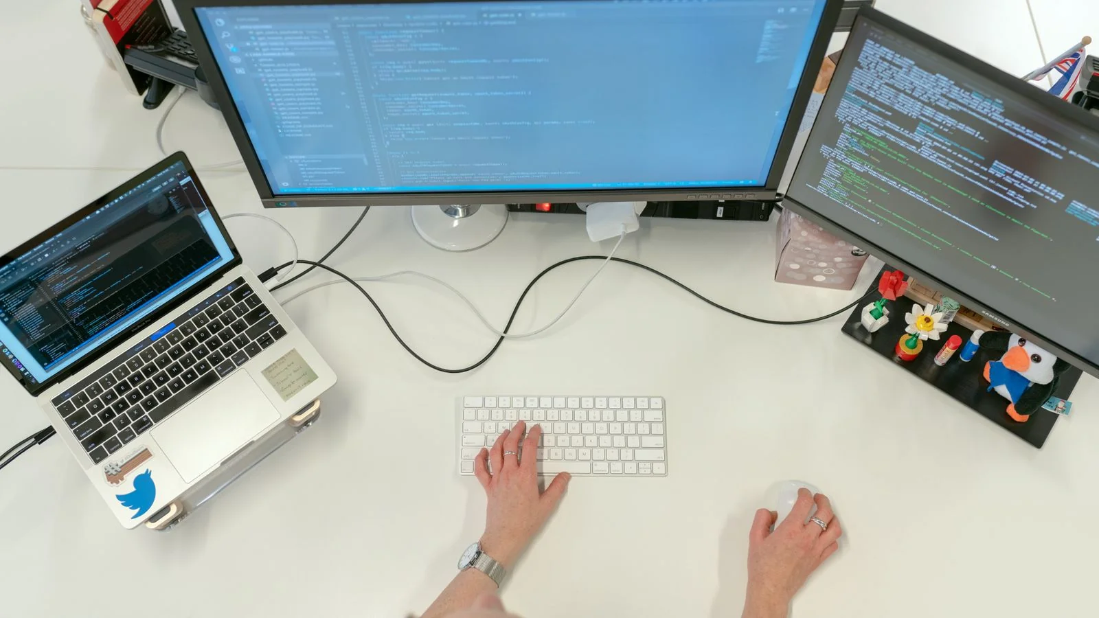 Software developer working on code across two screens
