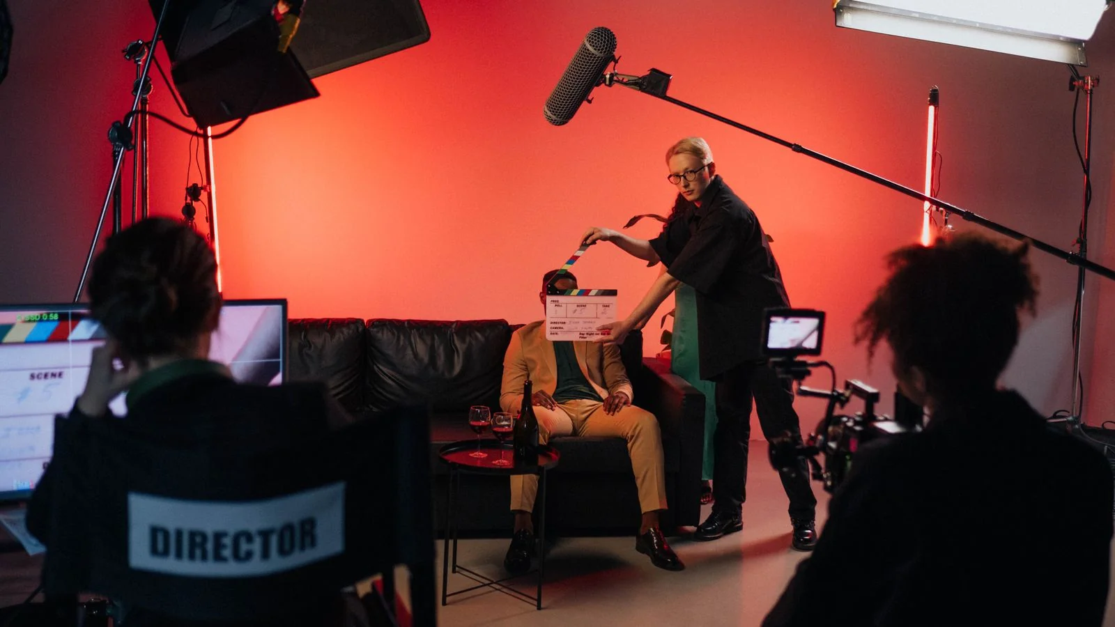Film crew setting up a scene indoors with lighting equipment, the credited work that anchors a performer's record