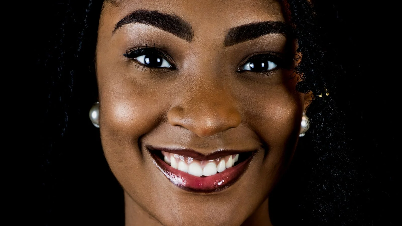 Portrait of a smiling professional against a dark background, the featured image a claimed panel lets you control