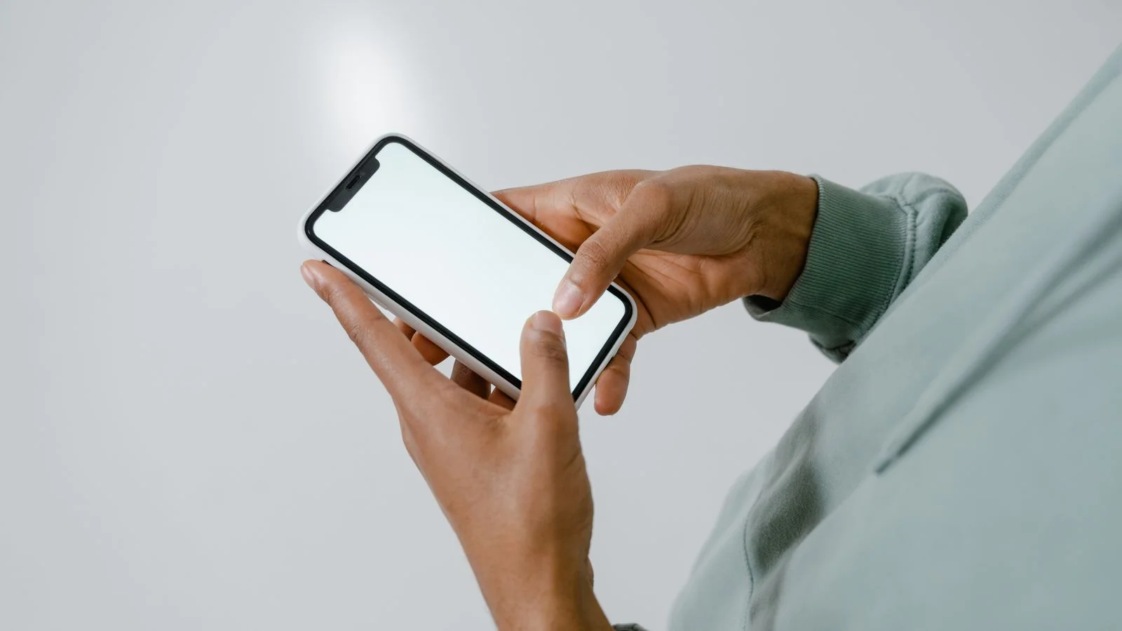 A person holding a smartphone, the device where most patients first encounter a dentist's search result
