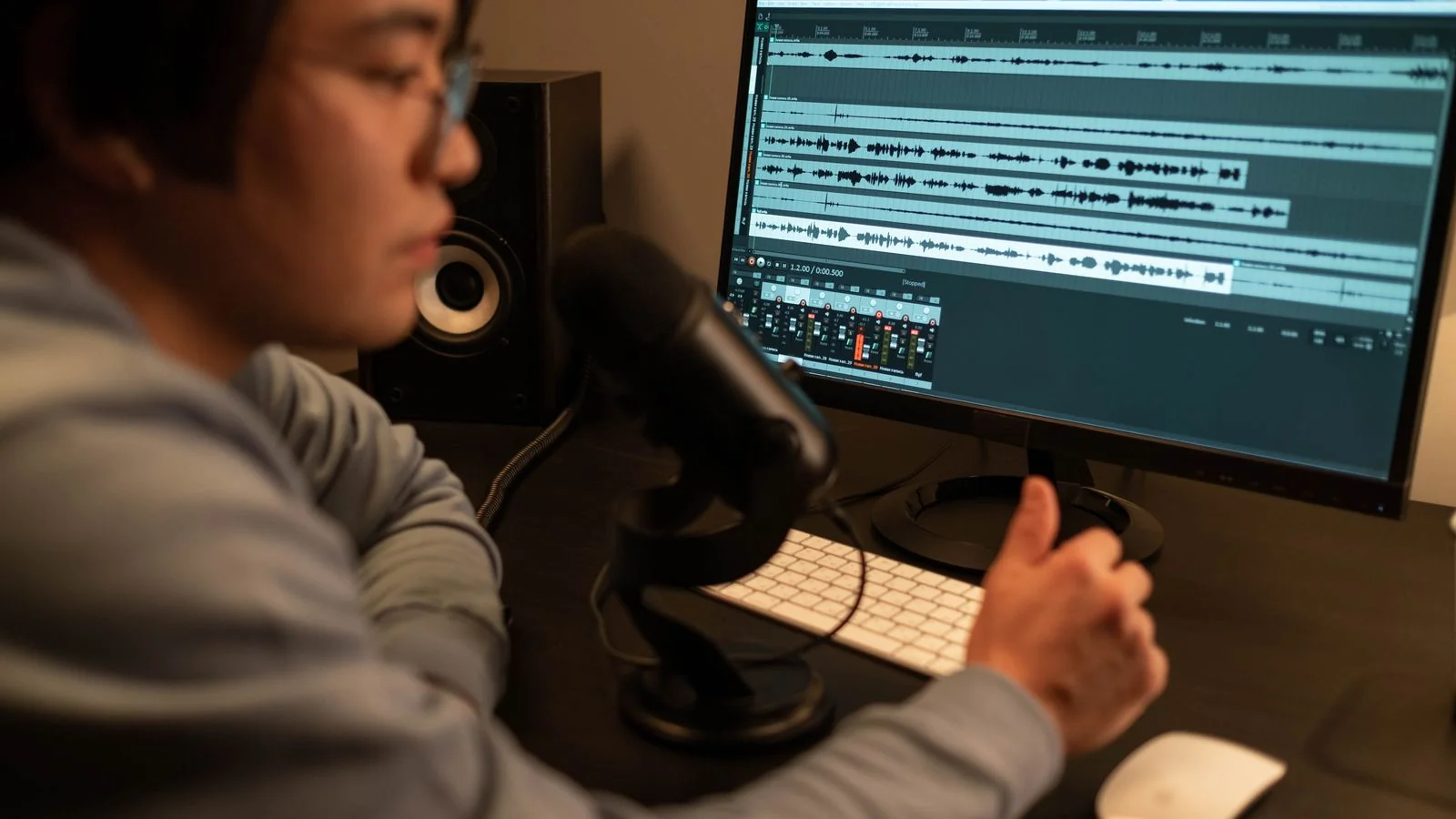Sound engineer editing audio on a computer in a recording studio, the consistent output that builds an entity record over time