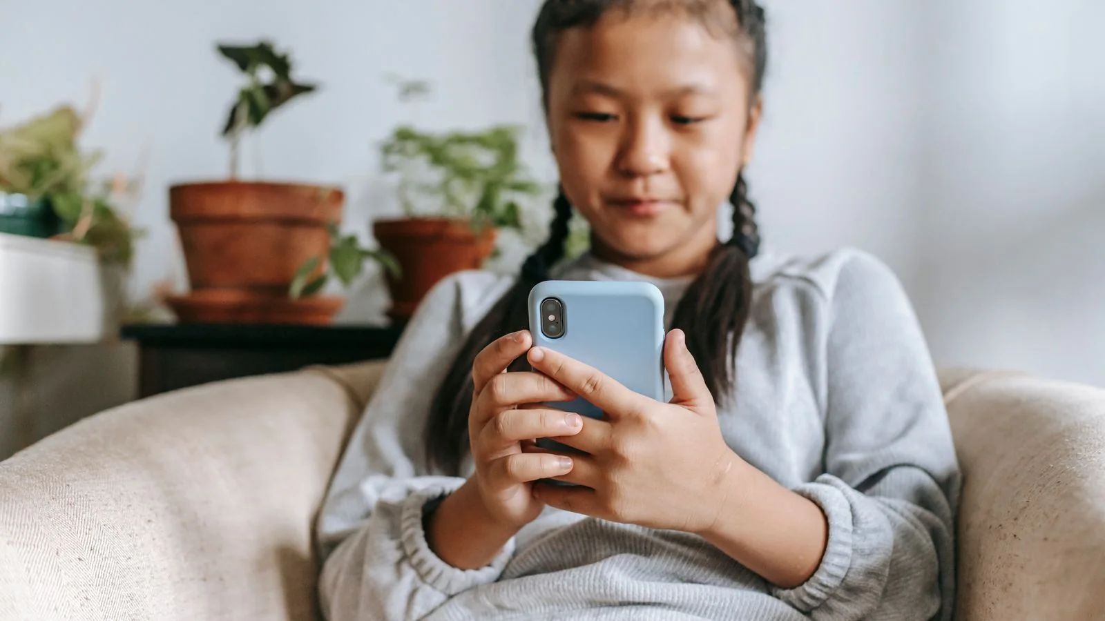 Person sitting in an armchair searching for something on a smartphone