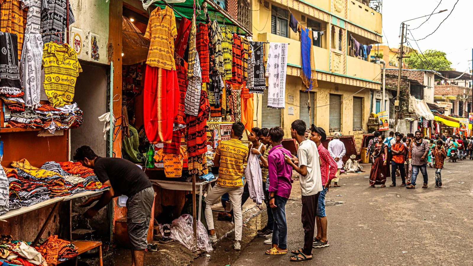 Busy street market with shoppers moving between stalls