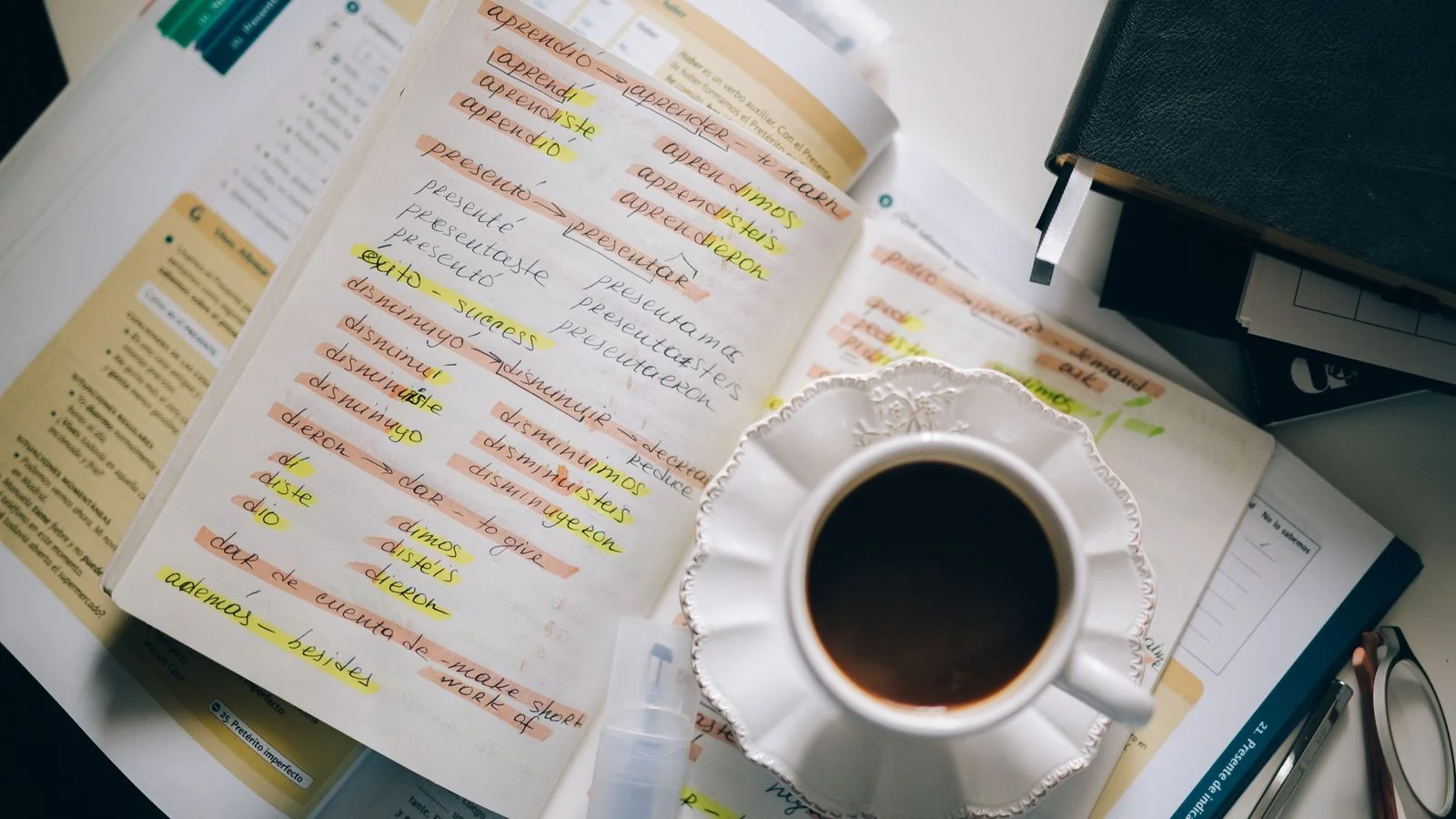 A cup of coffee resting on a page of handwritten notes and plans