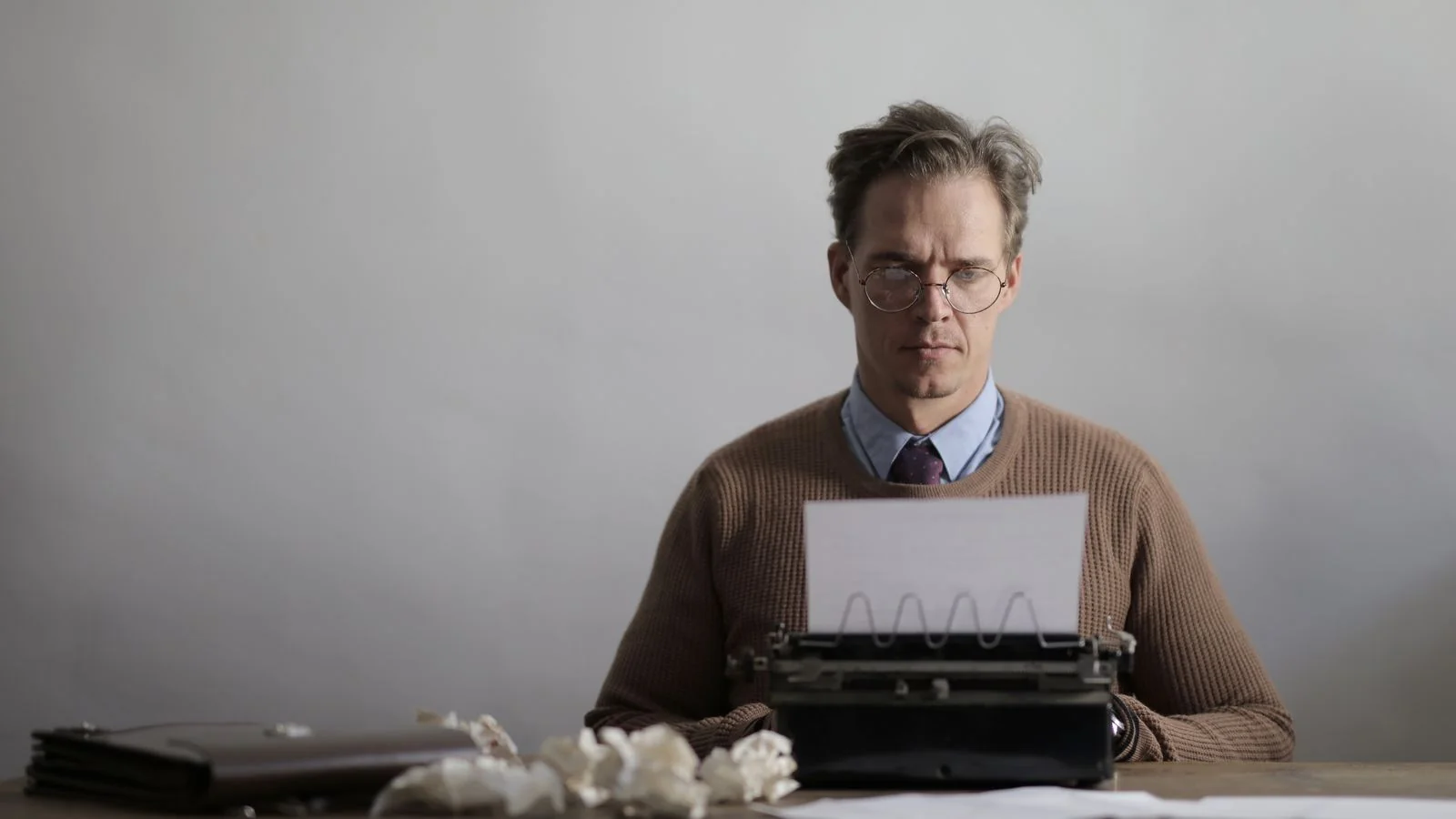 A focused writer typing at a desk, the human effort a strong source pitch still requires