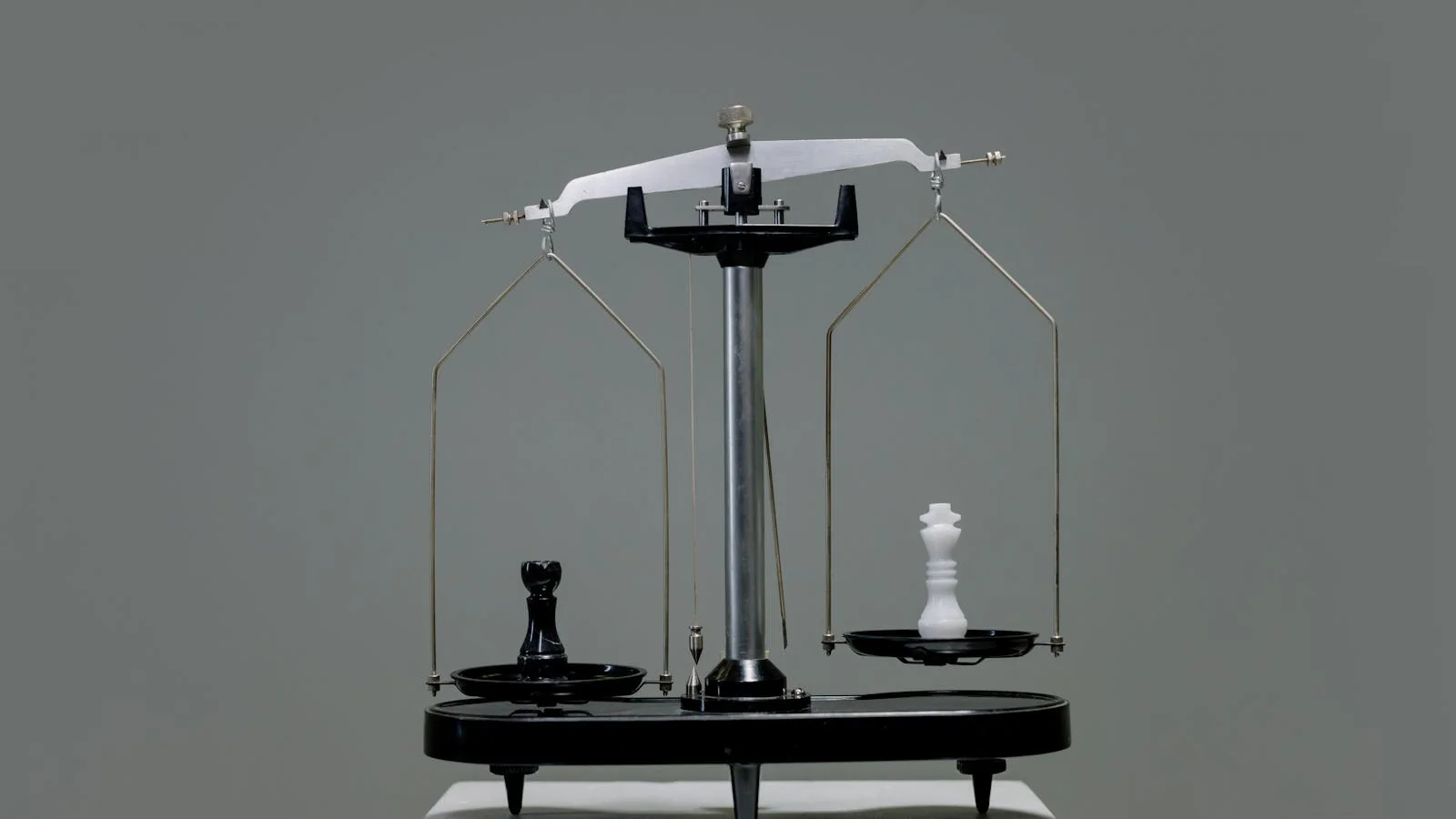 Chess pieces balanced on a scale representing the weighing of brand attributes in a competitive comparison decision