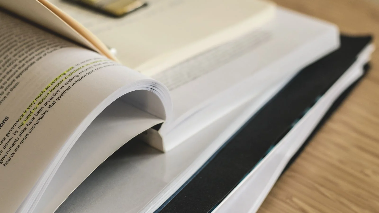 A pile of open books on a table, the kind of source depth ChatGPT weighs before it quotes