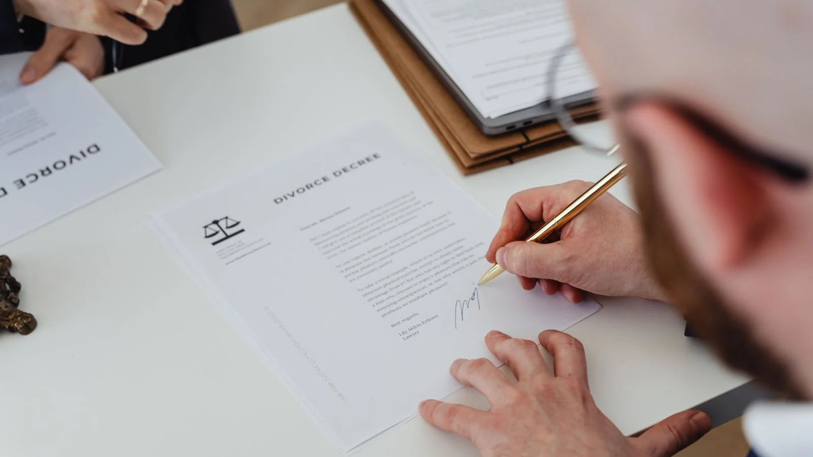 A person signing a document at a desk, the named authorship and consistent identity that make a source easier for DeepSeek to trust