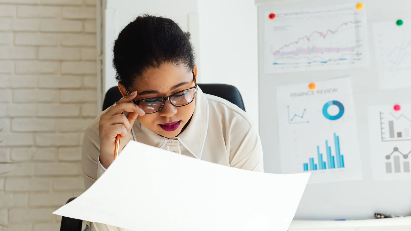 A businesswoman examining reports at a whiteboard, the expertise and track record signals that make a source safer to cite