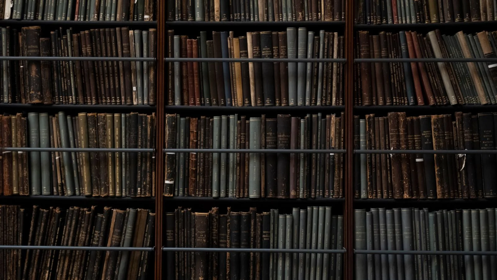 Rows of vintage books on library shelves, a reminder that Gemini draws from a vast corpus but quotes only a few