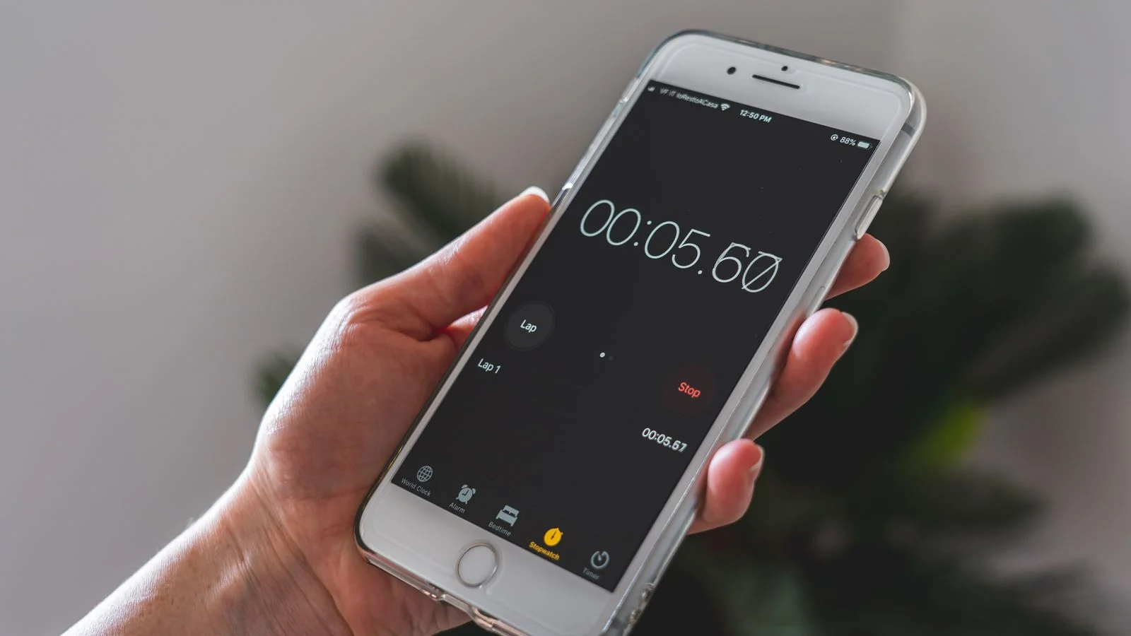 Hand holding a smartphone with a stopwatch app running