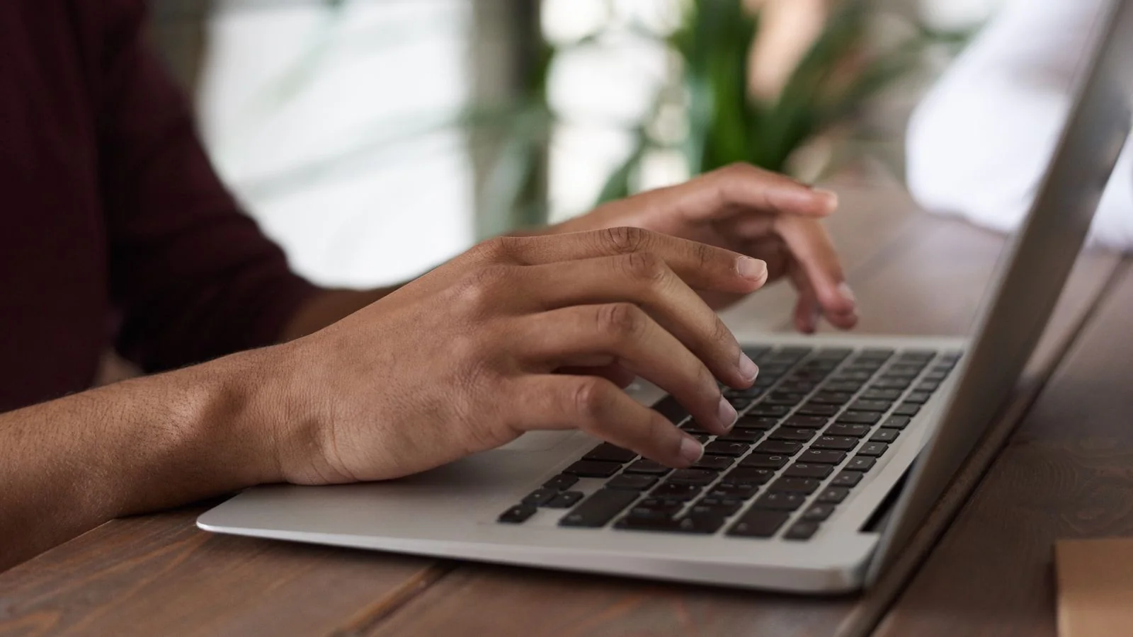 A person typing on a laptop, the close reading an answer engine performs to match a page to a question