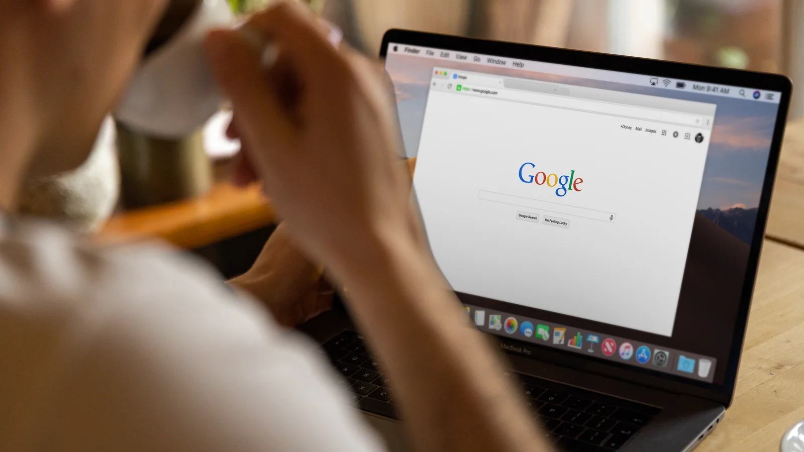 A person reviewing information on a laptop, checking a claim against other sources the way an engine corroborates