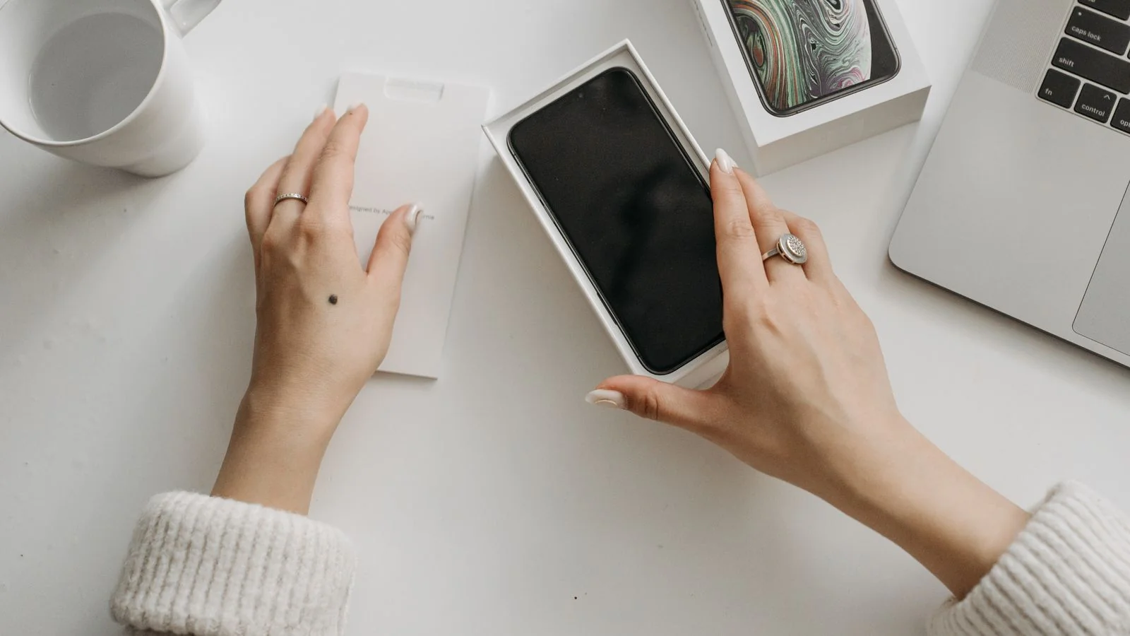 Person unboxing a product at a white table, one of dozens of moments that can trigger an honest review