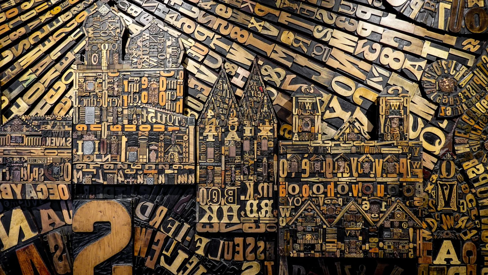 Wooden letterpress type blocks assembled into a dense typographic composition