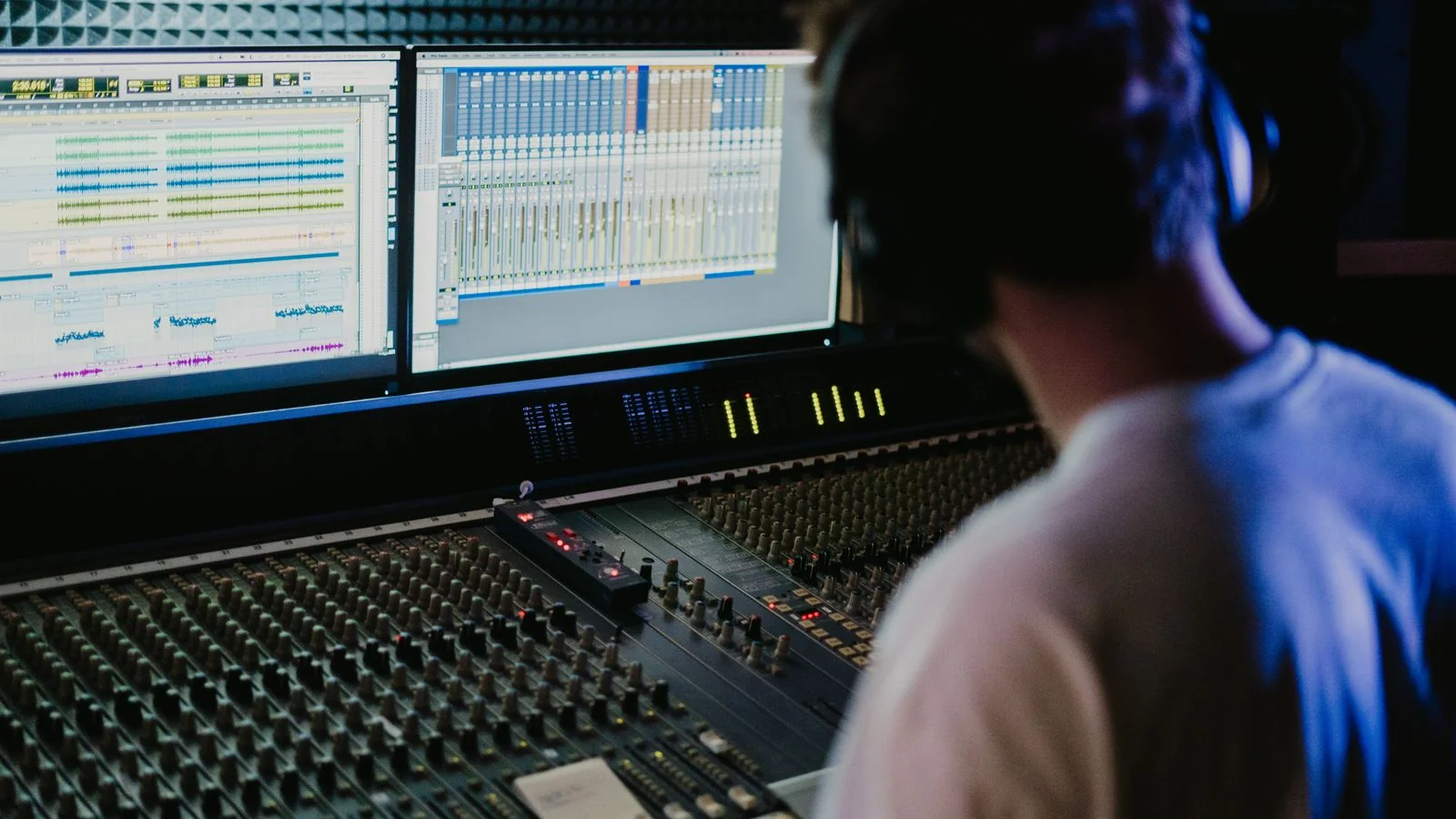 A sound engineer working a mixing console in a recording studio