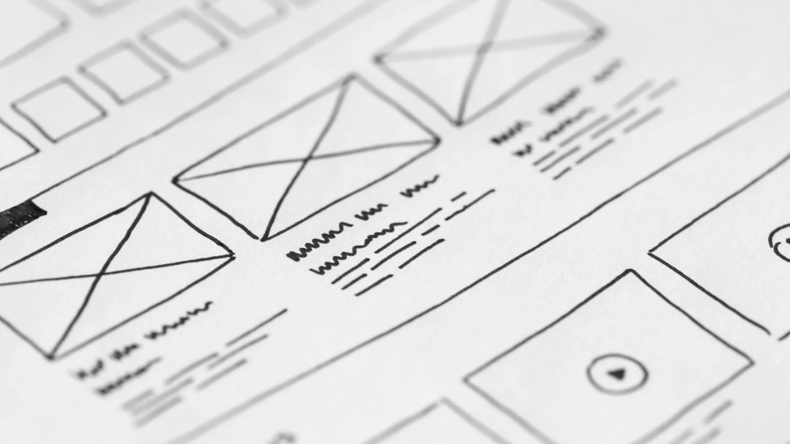 Hand-drawn website wireframes sketched on paper for a UX project
