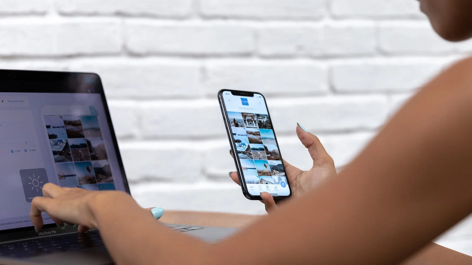 Founder using a laptop and smartphone to coordinate calendar and social posting