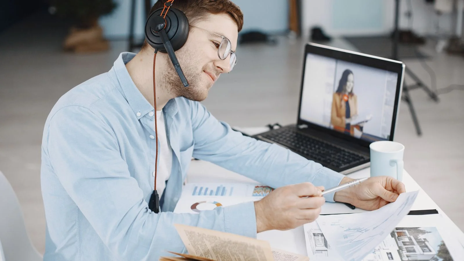 A person on a video call reviewing notes and documents, preparing the single problem their webinar will solve
