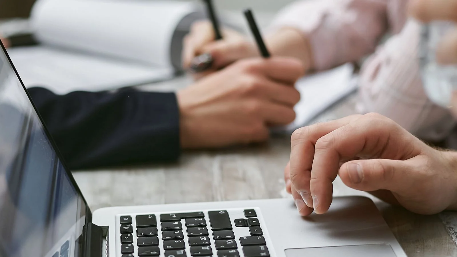 Colleagues collaborating over a laptop, a content team working from a shared brief template