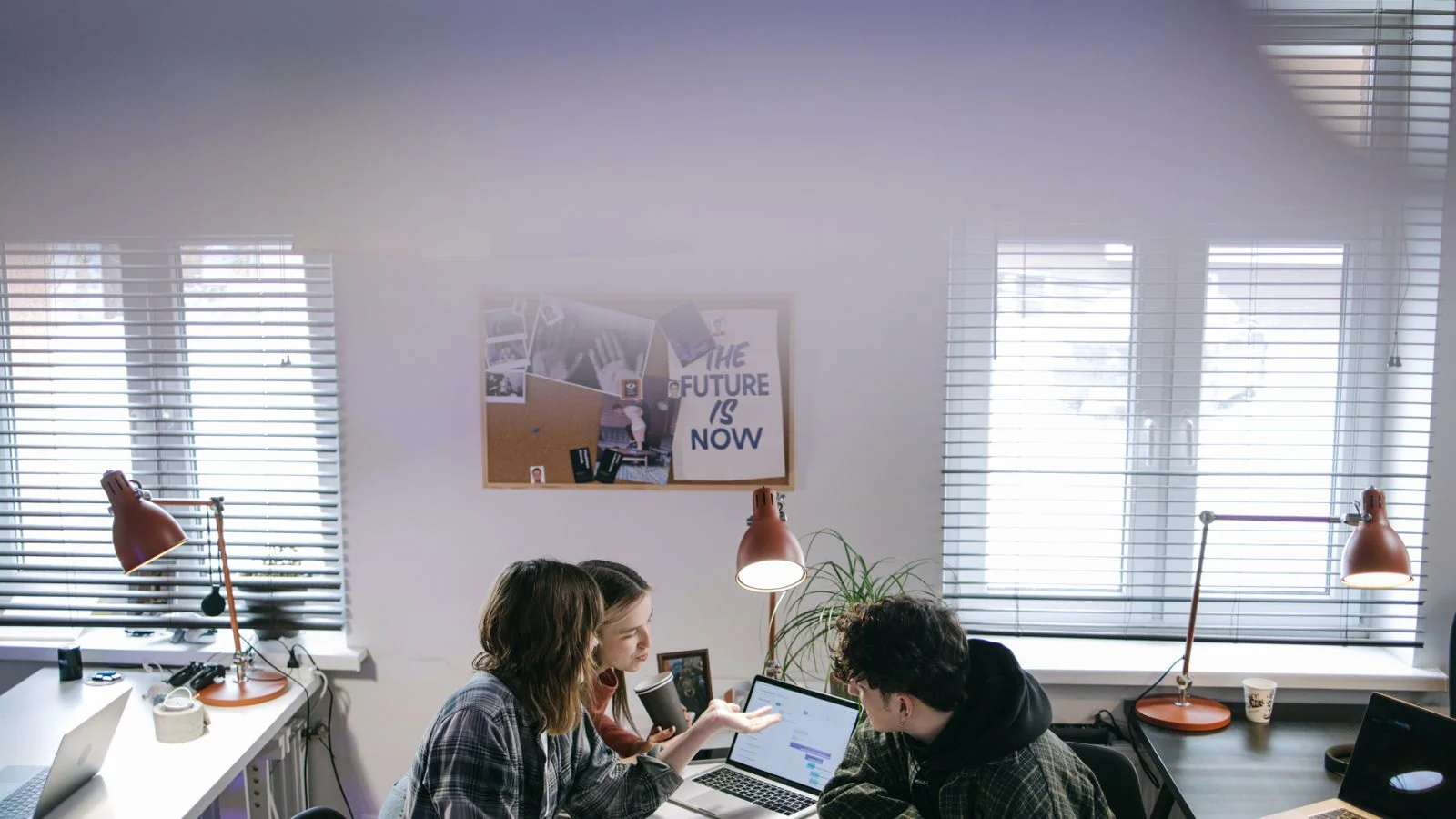 Colleagues reviewing information on a laptop together, aligning how a brand is described across the web