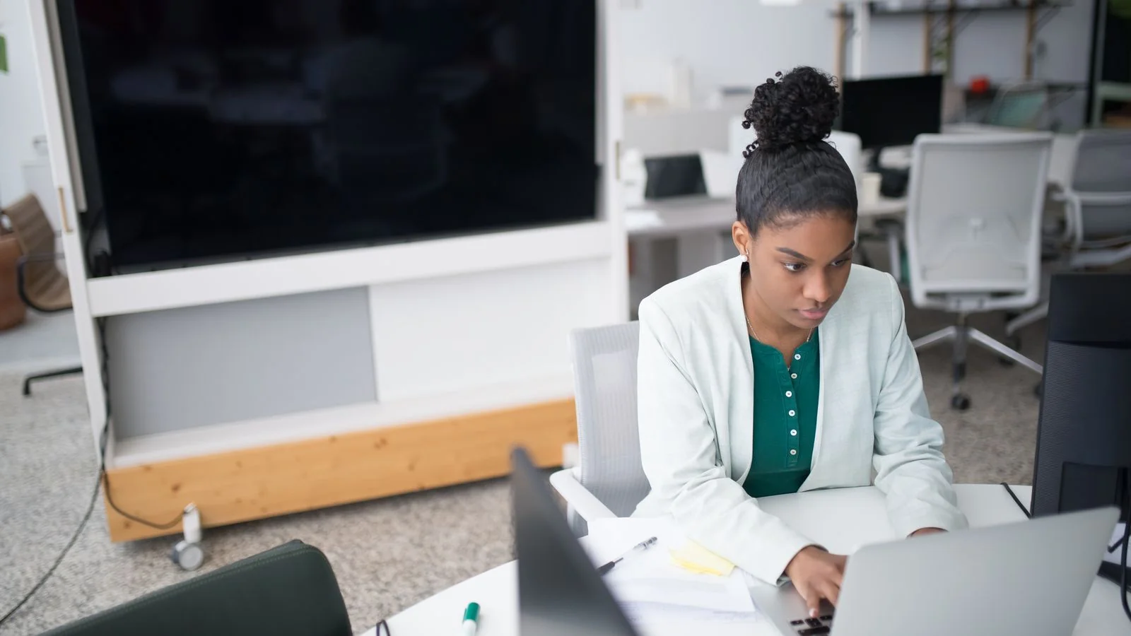 Woman in a blazer using a laptop, the kind of buyer who wants a number, not a 40-page guide