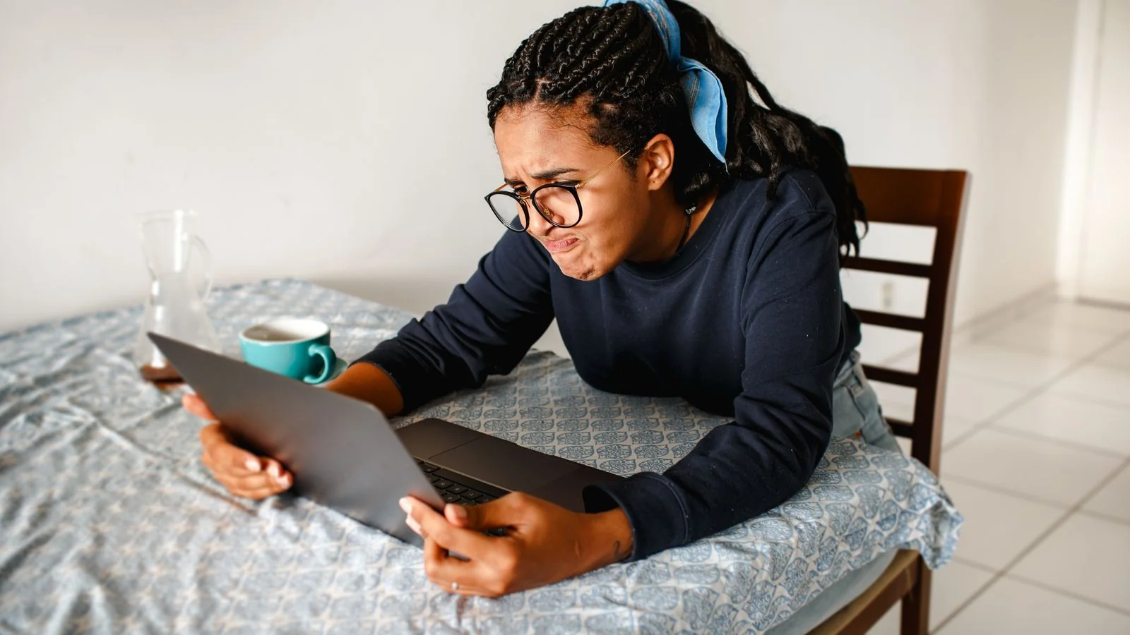 A woman studying a laptop screen, checking a reviewer's account for red flags.