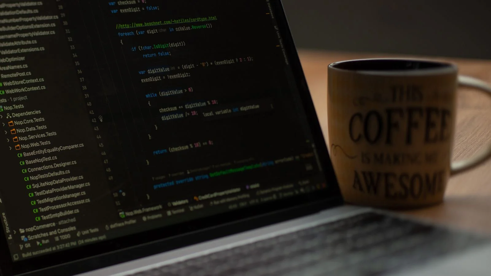 A laptop showing code next to a coffee mug, the working reality behind a technology story