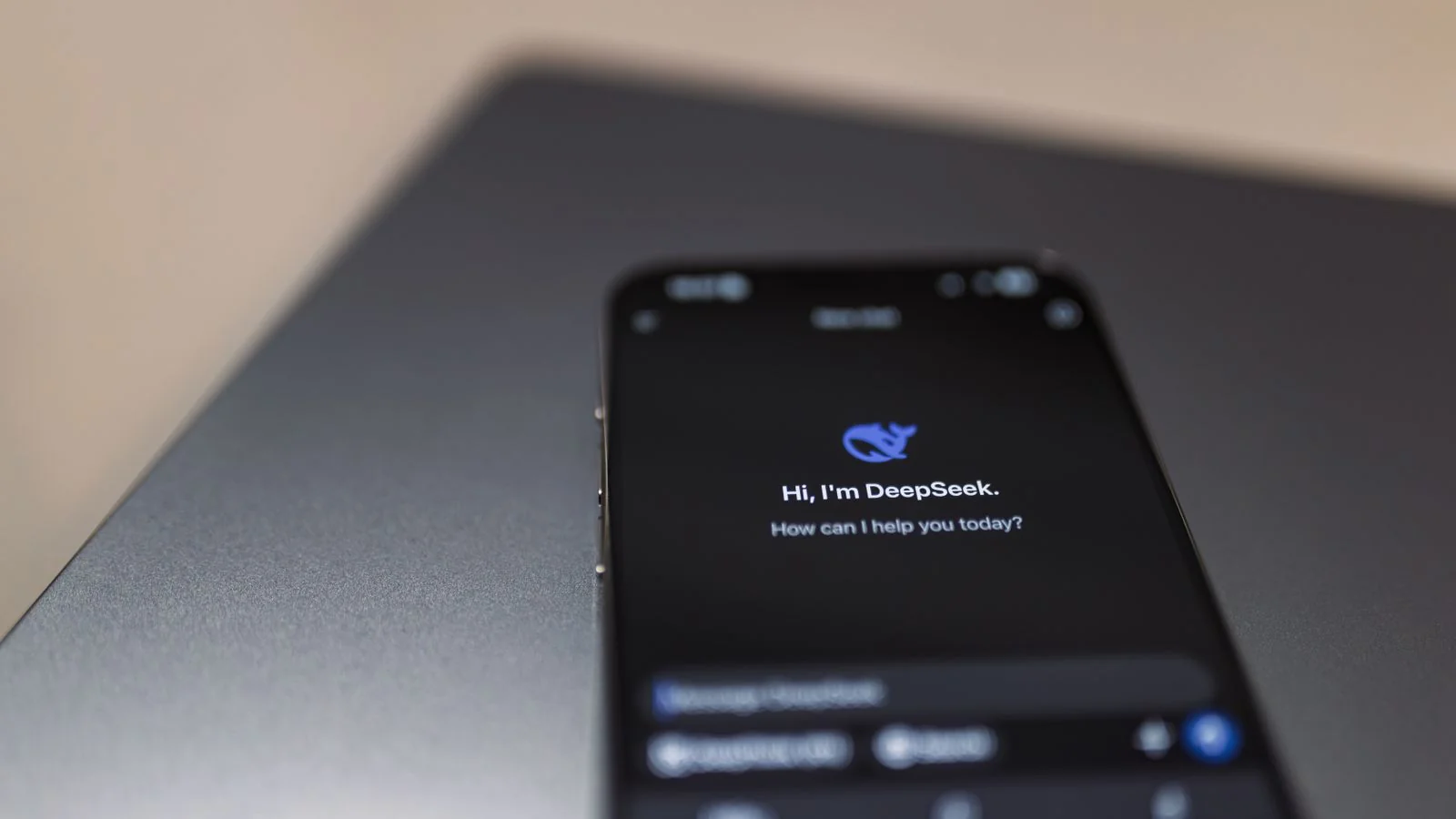 A smartphone showing an AI assistant interface resting on a laptop, where answers now get generated