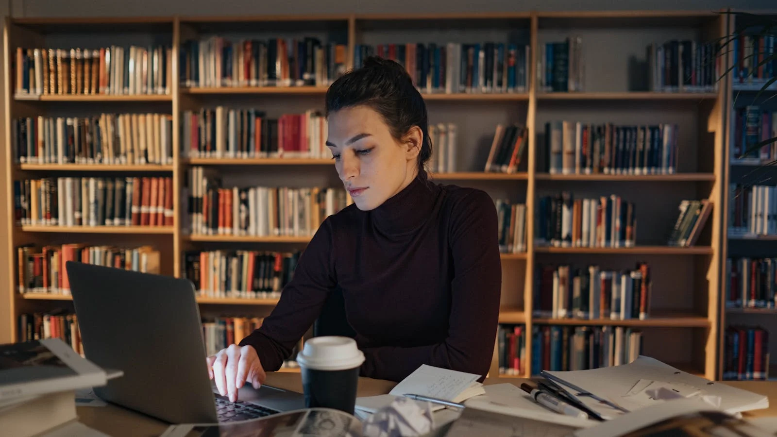 A researcher focused on a laptop, the way a roundup writer compares products in a category.