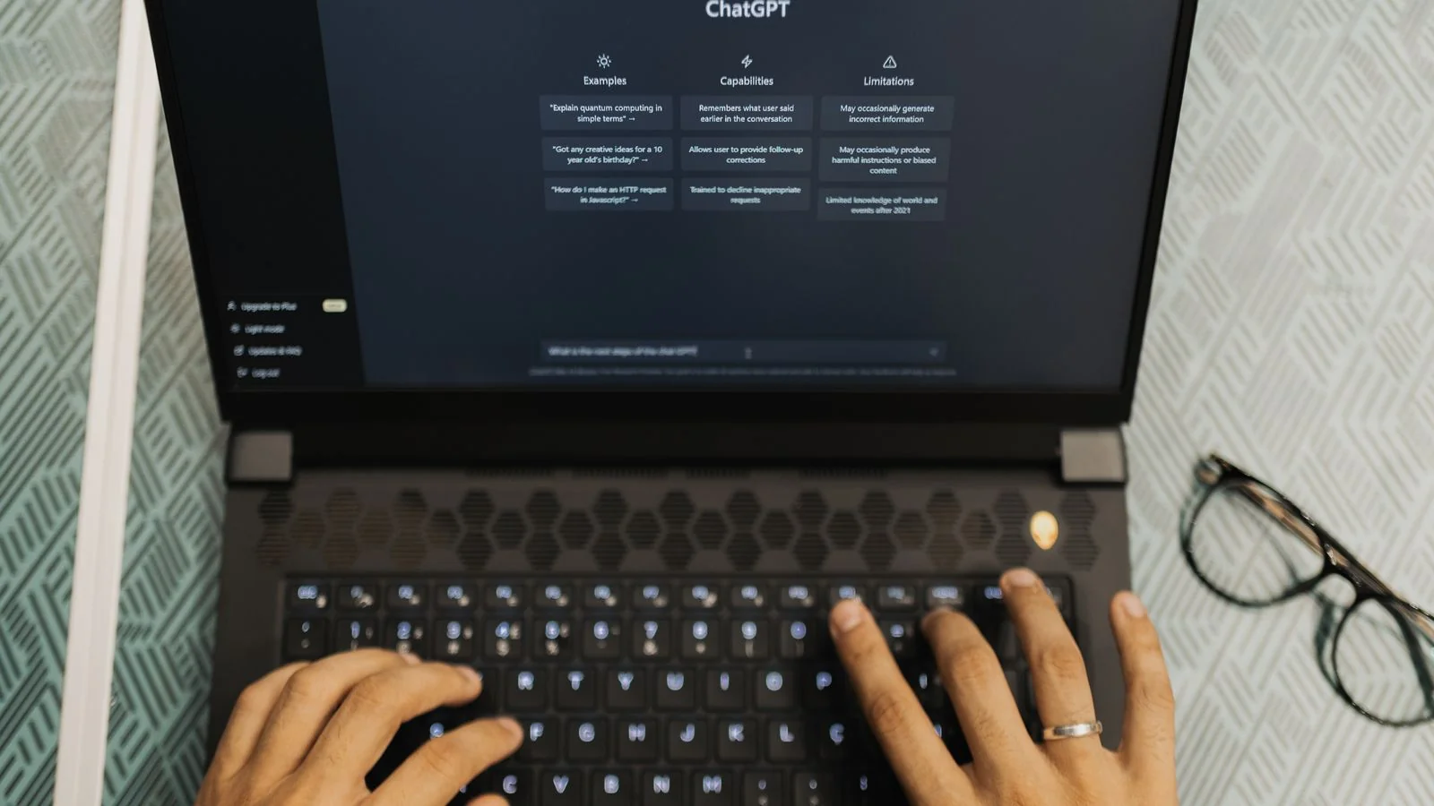 Hands typing on a laptop with an AI chat assistant open on the screen