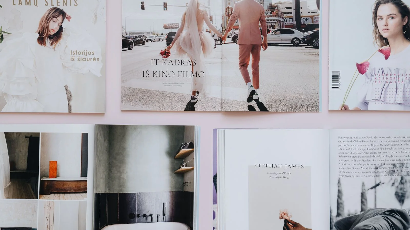 Open magazines spread across a table showing editorial layouts